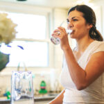 How much water should a person drink daily? The National Academies of Sciences, Engineering, and Medicine recommends approximately 91 ounces for women and 125 ounces for men, and this includes water from foods and beverages. Learn more: