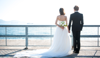 Partners looking out at the ocean on their wedding day.